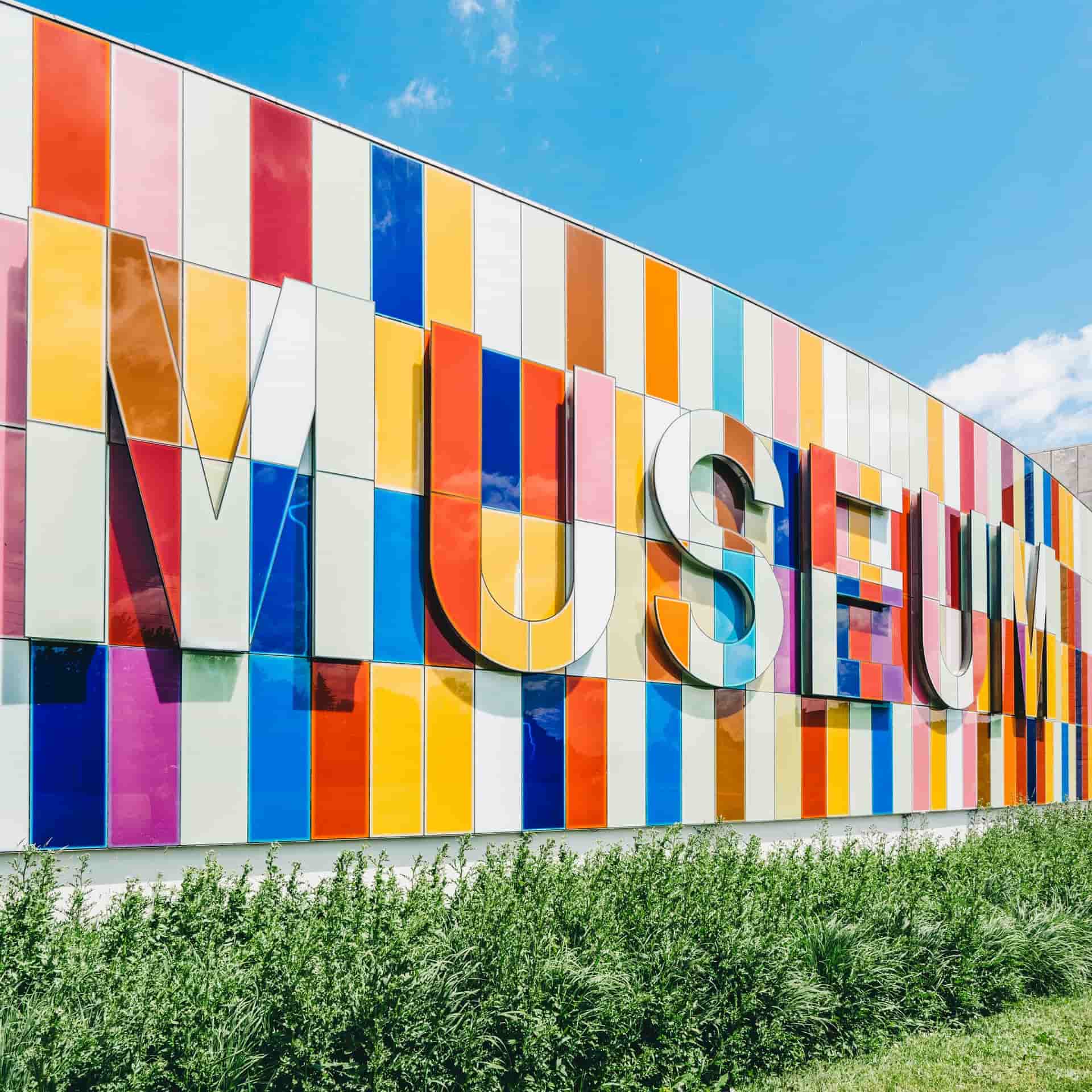 A wall it says Museum on. Its a very colorful wall with many different colors